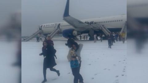 People running away from a plane.