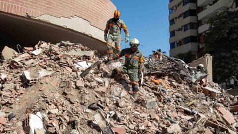 Members of rescue teams from Mexico are conducting search operations in a building damaged by an earthquake in La Guaira, Venezuela, 29 June 2026.