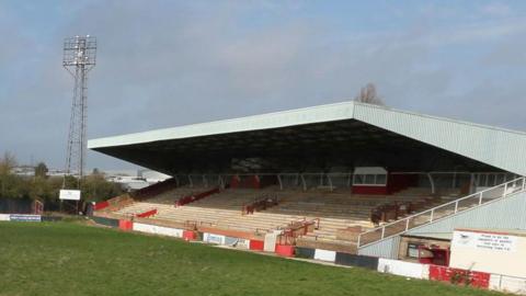 A derelict Rockingham Road as seen in 2013. The pitch has become visibly overgrown and the stadium appears in a poor general state of repair.