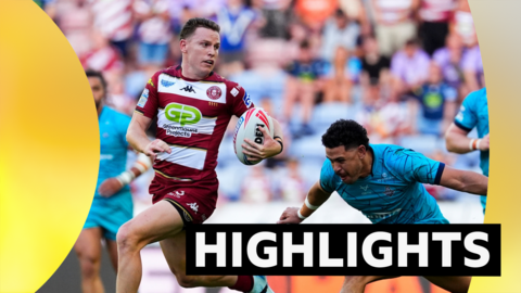 Jai Field of Wigan evades Jacob Gagai of Huddersfield