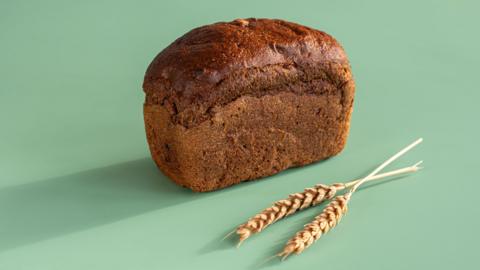 A loaf of rye bread on a pale green background
