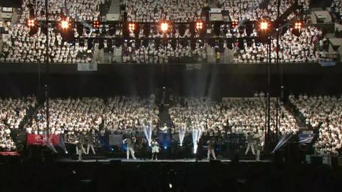 A wide shot of the Co-op Live arena, the stands are packed with children in white t-shirts