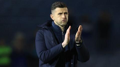 John Mousinho claps supporters at the end of a game