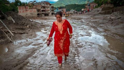  A resident walks along a muddy road following flash floods on August 27, 2026 in Trishuli, Nepal. A sudden flood swept through the Bhote Koshi River basin in northern Rasuwa on August 26,