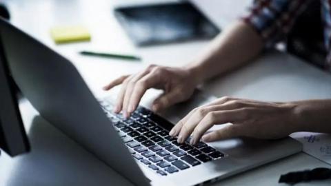 The image is a generic photo of a woman's resting on the keyboard of the laptop, on a desk.