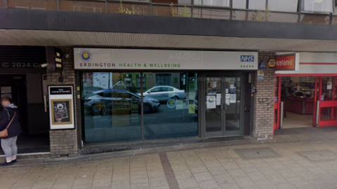 The front entrance to a high street unit with the words Erdington health and wellbeing above the doors