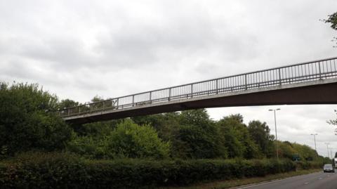 A concrete footbridge passing over a bypass