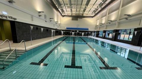 A four-lane swimming pool at the Station Leisure and Learning Centre, with bunting hanging above the pool 