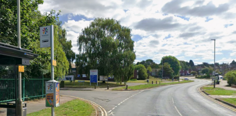 A residential road with a bus stop near it