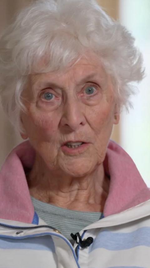 An elderly woman with short, white hair looking into the camera.