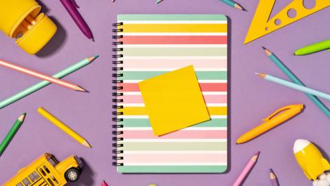 Colored pencils and notepad on lilac pink, back to school and art and creativity concept. Mockup sticky note on top