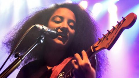 English Teacher singer Lily Fontaine playing the guitar on stage