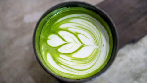 An aerial shot of a cup of green and white matcha coffee.