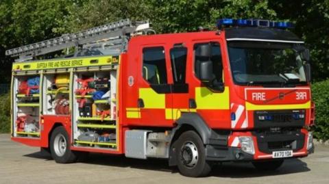 A fire engine with the side open and ladder on top