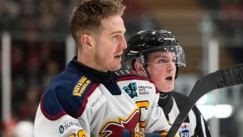 Brett Ferguson looks on from the side of the rink