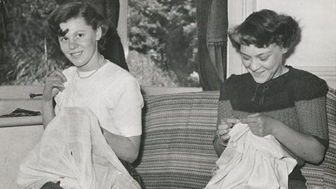 A black and white image of two women sewing. 