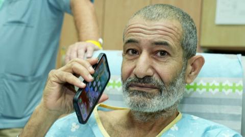 Israeli government handout photo showing rescued Bedouin hostage Kaid Farhan Elkadi holding a phone at Soroka Medical Center in Beersheba, Israel (27 August 2024)