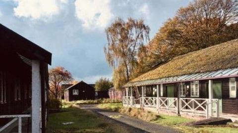 World War Two barracks at Ripon in North Yorkshire. The barracks are built of wood and are single storey with doors painted green and windows in white.