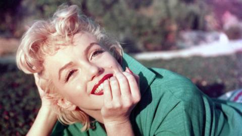 A woman, Marilyn Monroe, wearing a green top.