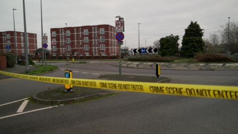 A close up of yellow crime scene tape which surrounds a roundabout close to where the crash took place.