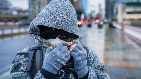 a lady wrapped up for the bad weather