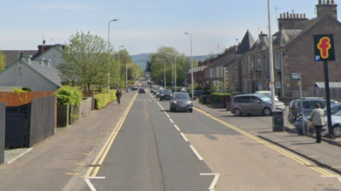 A road with houses and shops on either side