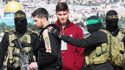 US-Israeli Sagui Dekel-Chen and Russian-Israeli Sasha (Alexander) Troufanov are escorted by Hamas militants and Islamic Jihad militants as part of a hostage-prisoners swap in Khan Younis, 15 February