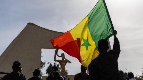 Activists, one holding a Senegalese flag, take part in a march against homosexuality in Dakar, Senegal, 06 March 2026