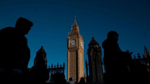 People in shadow walking past Big Ben