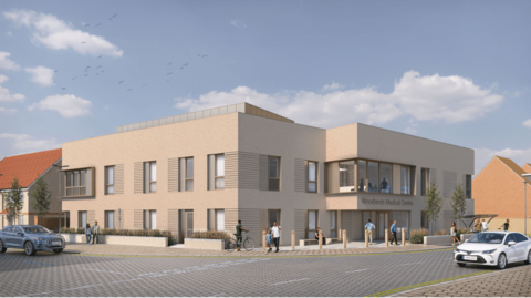 An artist's impression shows what the new GP surgery will look like. It is on the corner of two roads, and is a beige building with large windows. It says "Woodlands Medical Centre" on one side. 