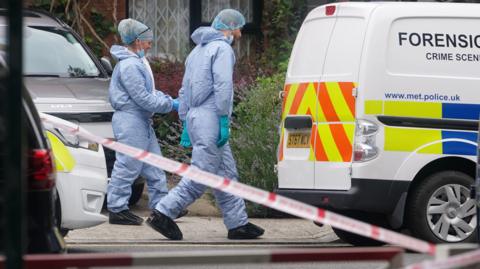 Forensic officers and a police van at an address in Shepherd's Bush