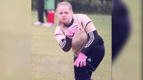 A close-up of Rhiannon in action on the pitch in her goalkeeper kit - with bright pink gloves