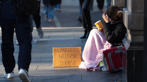 A homeless person begs on the streets of London.
