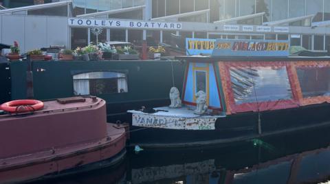 Three colourful canal boats in front of Tooley's Boatyard.