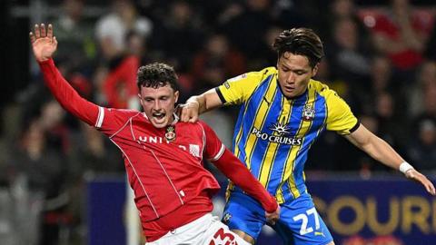  Nathan Broadhead of Wrexham is challenged by Kuryu Matsuki of Southampton 