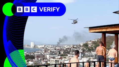 Tourists in Puerto Vallarta watch on as smoke rises in the distance and a military helicopter is seen flying low over hotels 