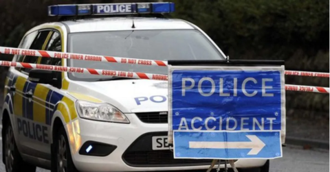 Police car at a closed road with an accident sign