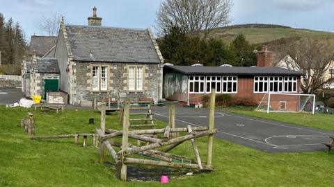 A small school in the Borders with a playground and play equipment outside