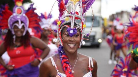 A woman in red and purple costume taking part in a parade