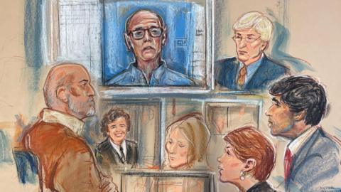 A court sketch showing a composite of various different people in court. It shows a TV screen at the back with an illustration of Ian Paterson - a man wearing glasses and a blue shirt. Underneath the screen is an illustration of Phyllis Colfer, the subject of the inquest, with brown curly hair and wearing a black uniform. On the left is a man with a silver beard and a brown coat, who is Phyliss' son. There are also two woman and two men drawn in the image, representing the coroner, barristers, and the counsel to the inquest.
