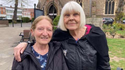 Two women are stood in the middle of Redditch town centre - Pearl Noonan and Lynn Spiers. 
