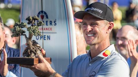 Justin Rose is presented the Championship trophy after winning the Farmers Insurance Open
