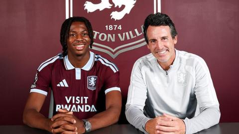 Johan Manzambi wears his Aston Villa shirt and sits with Unai Emery