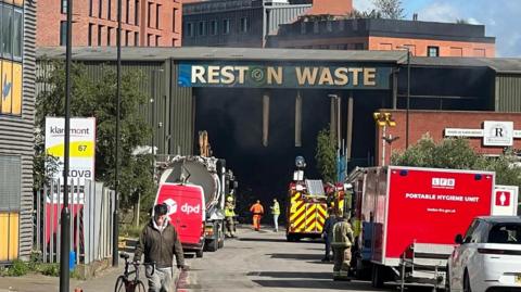 Exterior shot of Reston Waste Management, with fire vehicles outside 