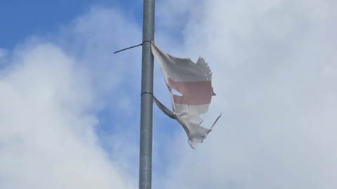 A ragged St George flag on a lamppost