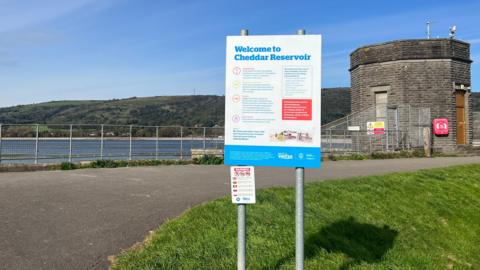 A view of the Cheddar Reservoir information sign and dam.