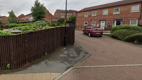 A photo of Ribston Mews, in Sheffield. It is a small cul-de-sac lined with terraced houses on the right-hand-side of the photo.