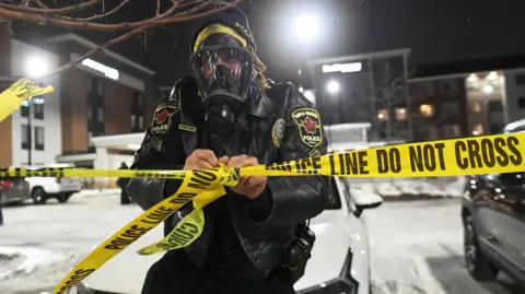 Police put up tape as protesters gather outside the hotel where top Border Patrol official Gregory Bovino is believed to be staying, in Maple Grove, a suburb of Minneapolis, Minnesota, USA, 26 January 2026.