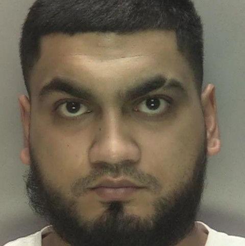 Azeem Hussain in a photo taken by police with a black beard, short black hair and a white top