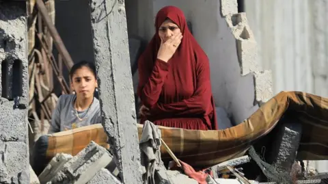 A woman and child assessing damage in Gaza  